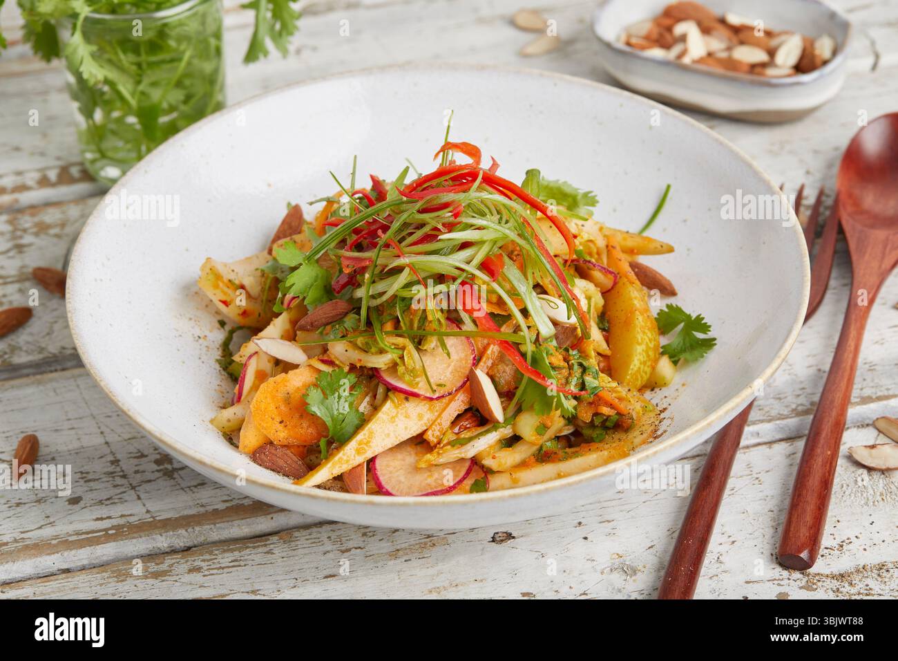 Frischer napa-Kohl mit knusprigen Karotten und süßer Birne – ein leichtes und farbenfrohes Gericht auf Pflanzenbasis, perfekt für ein rohes veganes Mittagessen oder einen gesunden Beilagensalat. Stockfoto