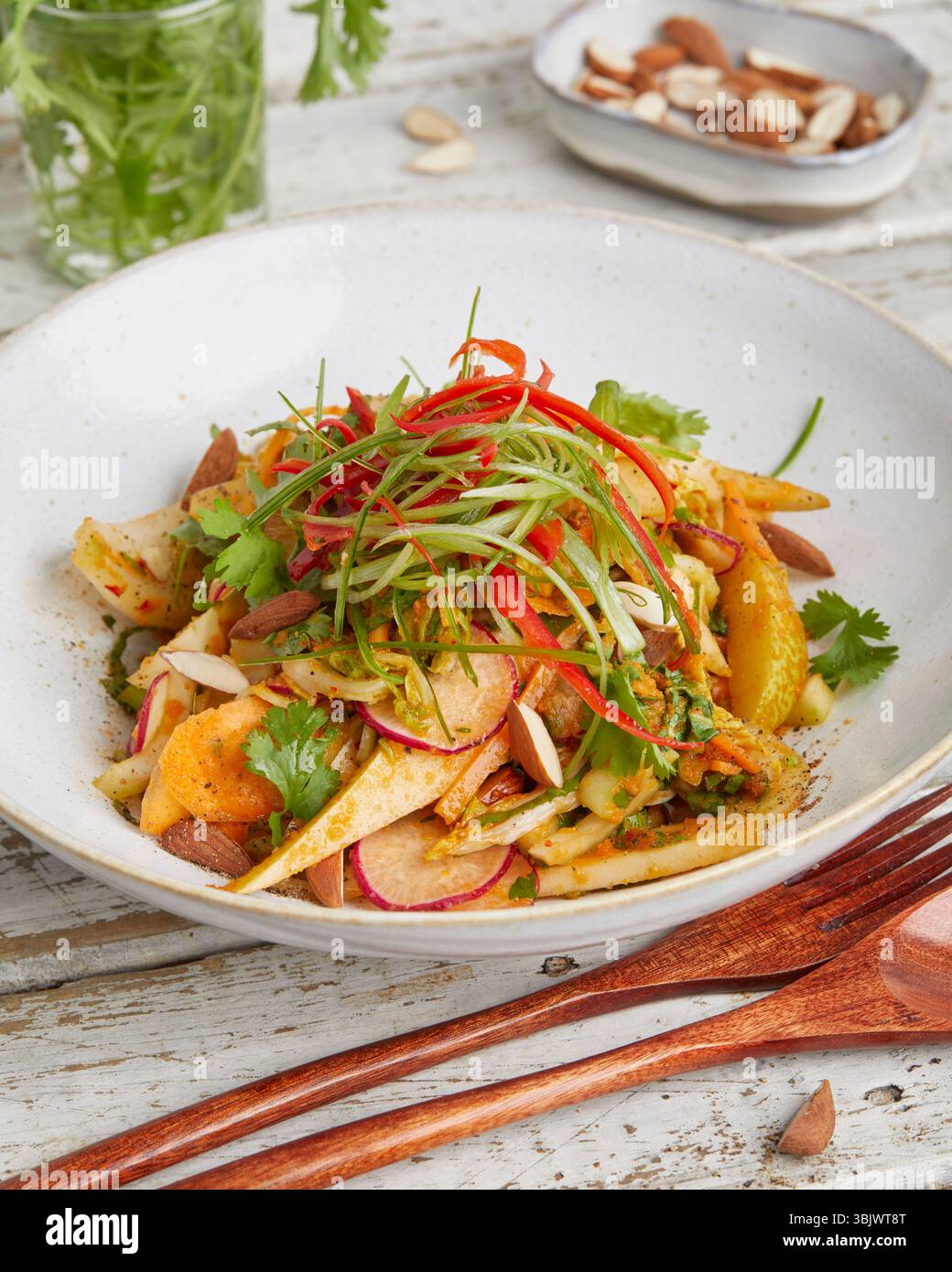 Frischer napa-Kohl mit knusprigen Karotten und süßer Birne – ein leichtes und farbenfrohes Gericht auf Pflanzenbasis, perfekt für ein rohes veganes Mittagessen oder einen gesunden Beilagensalat. Stockfoto