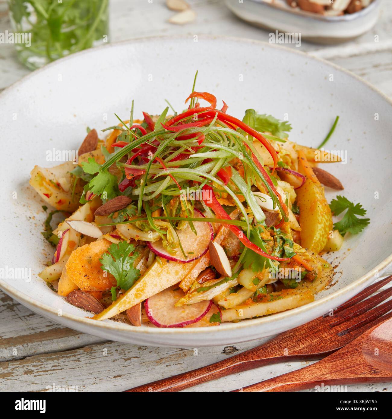 Frischer napa-Kohl mit knusprigen Karotten und süßer Birne – ein leichtes und farbenfrohes Gericht auf Pflanzenbasis, perfekt für ein rohes veganes Mittagessen oder einen gesunden Beilagensalat. Stockfoto