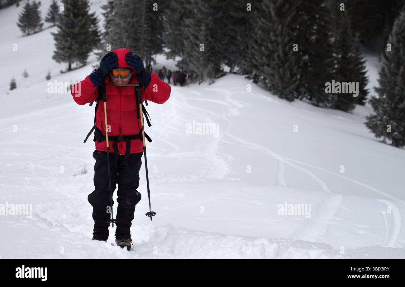 Wanderer mit Händen auf Kopf an abseits der Pisten verschneite Pisten in schneebedeckten Wäldern Stockfoto