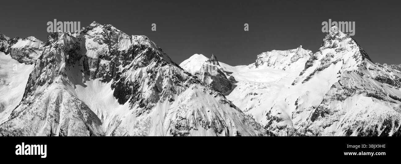 Schwarz-weiß-Panorama von schneebedeckten Berggipfeln Stockfoto