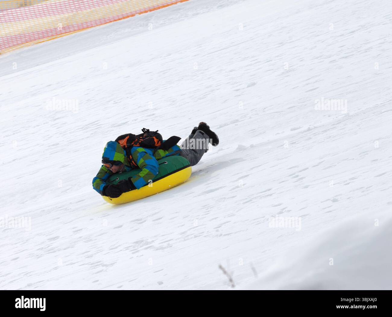 Snowtubing im Skigebiet am Sonnentag in verschneiten Bergen Stockfoto