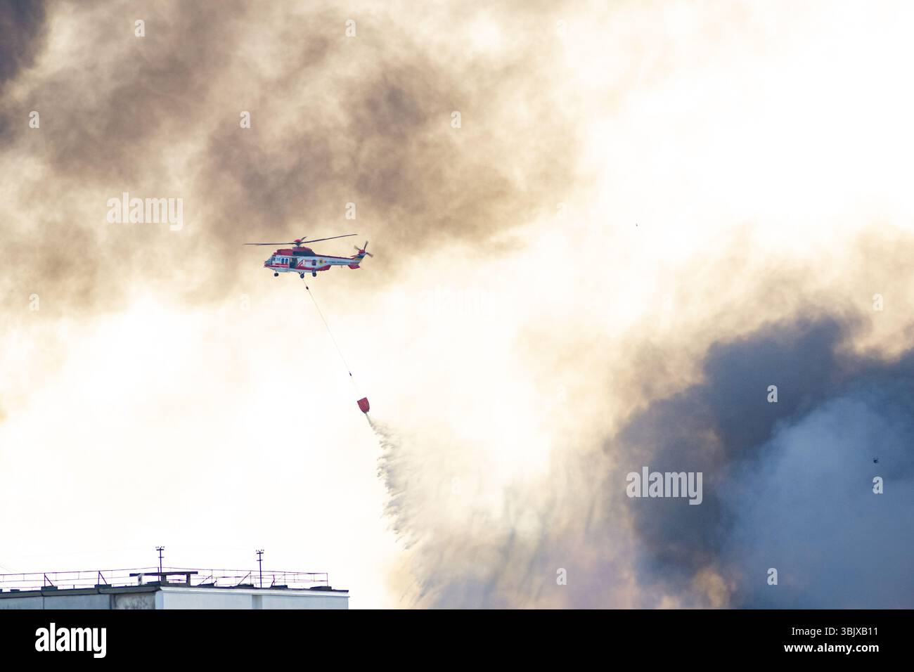Kiew, Ukraine. Juni 2025. Ein Rettungshubschrauber lässt Wasser fallen, um das Feuer nach einem Raketenangriff in Kiew, Ukraine, zu löschen. Notfallreaktion nach einem Luftangriff. Quelle: Arkadija/Alamy Live News Stockfoto