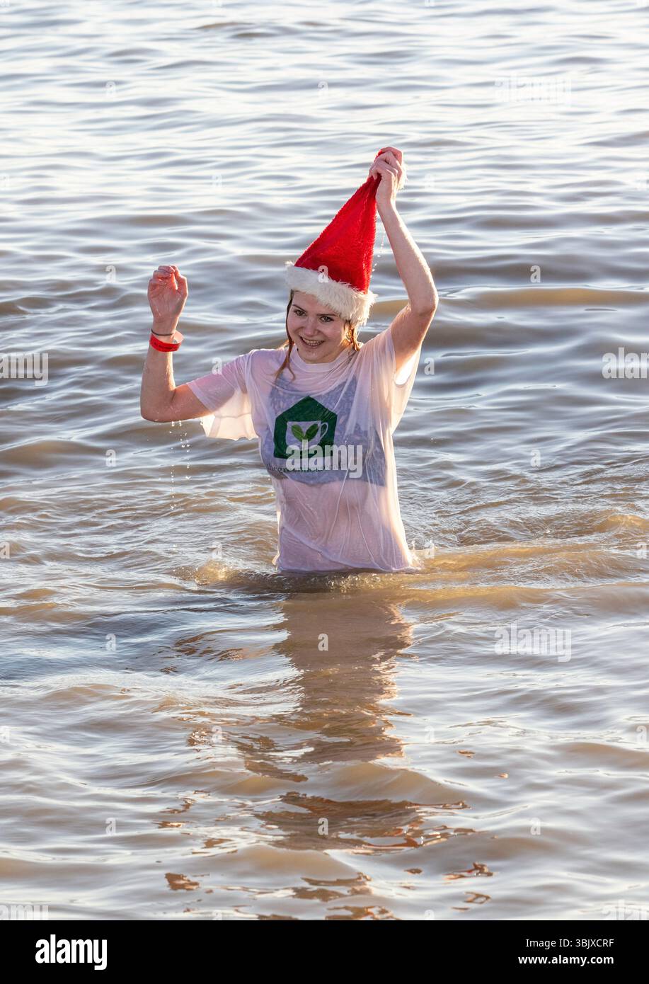 Jedes Jahr am Weihnachtsfeiertag schwimmen viele in schicken Kleidern in der Nordsee in Felixstowe als Spendenaktion für das St. Elizabeth Hospiz, definitiv kaltes Wasser. Stockfoto