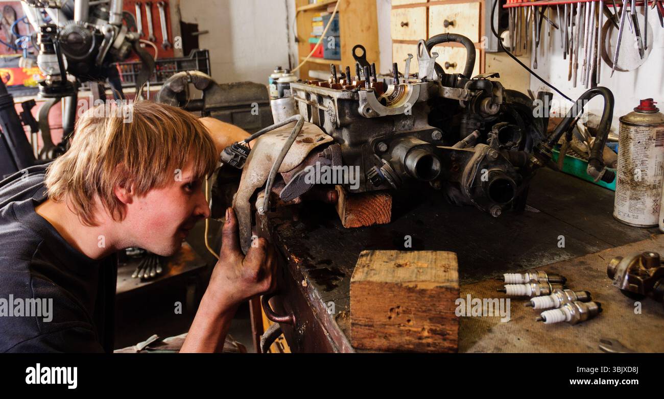 Arbeiter repariert den Fahrzeugmotor Stockfoto
