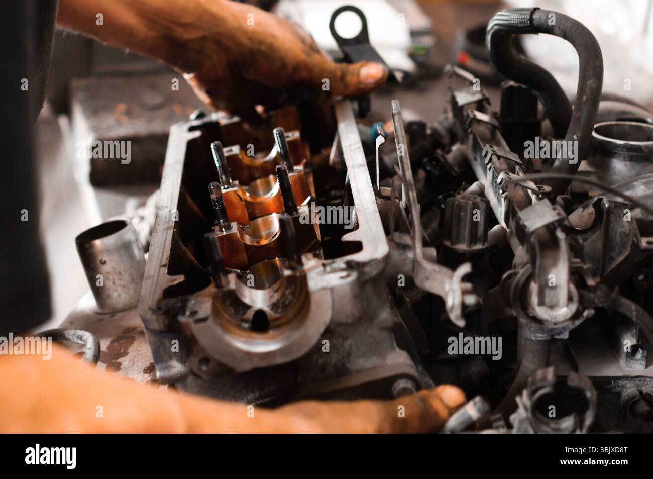 Gebrauchte Motorblock mit den Händen eines Arbeiters Stockfoto