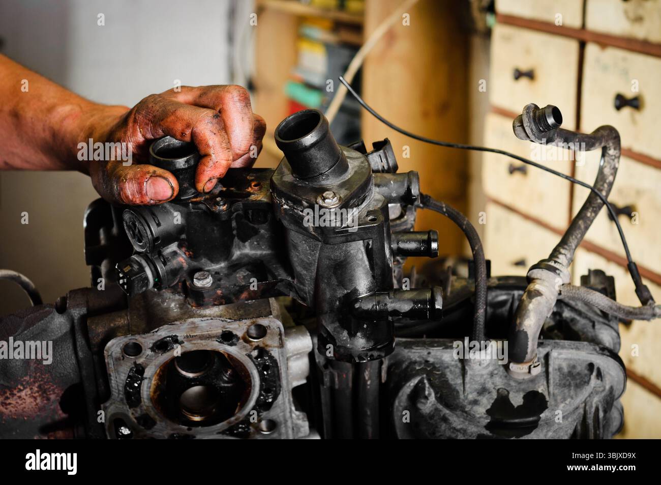 Arbeiter repariert defekten Motor in der Garage Stockfoto