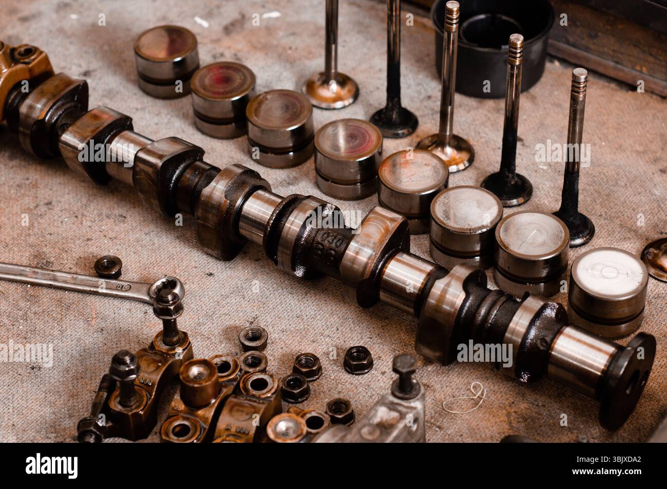 Fettige Motorblockteile auf Holzplatte schließen Stockfoto