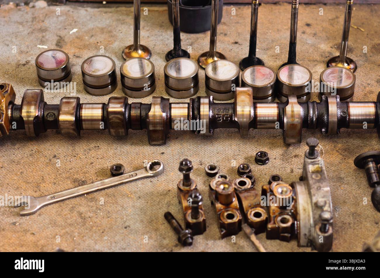 Die Nockenwelle des Autos auf der hölzernen schmutzigen Platte Stockfoto