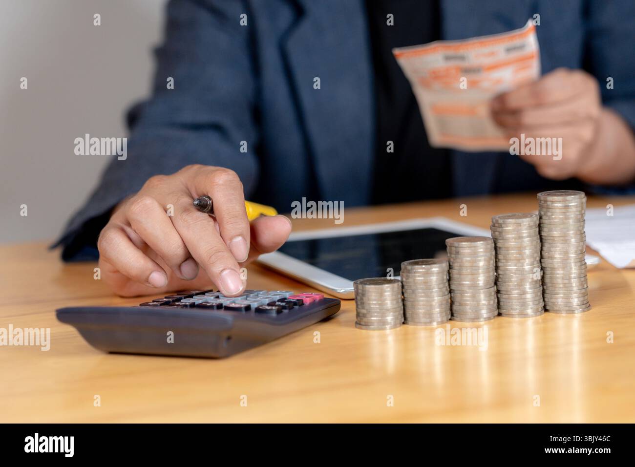 Teilansicht des Mannes, der das Haushaltsbudget verwaltet, mit Rechner und Dokumenten auf der Tabelle. Stockfoto