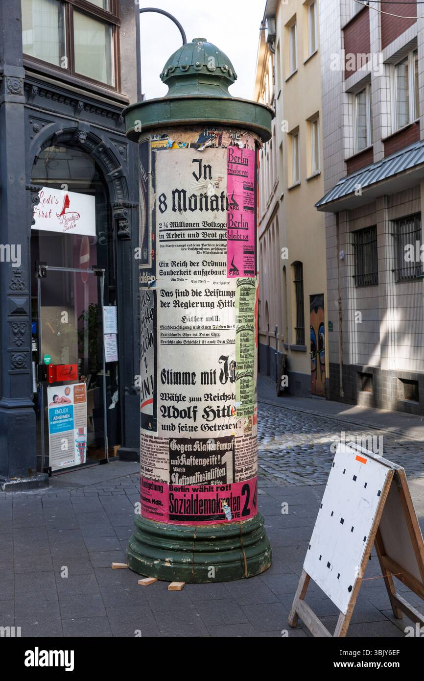 Filminszenierung in der Straße Stavenhof im Eigelstein-Viertel, politische Plakate aus den 1930er Jahren auf einer Werbesäule, Köln. ###EDITORIAL Stockfoto