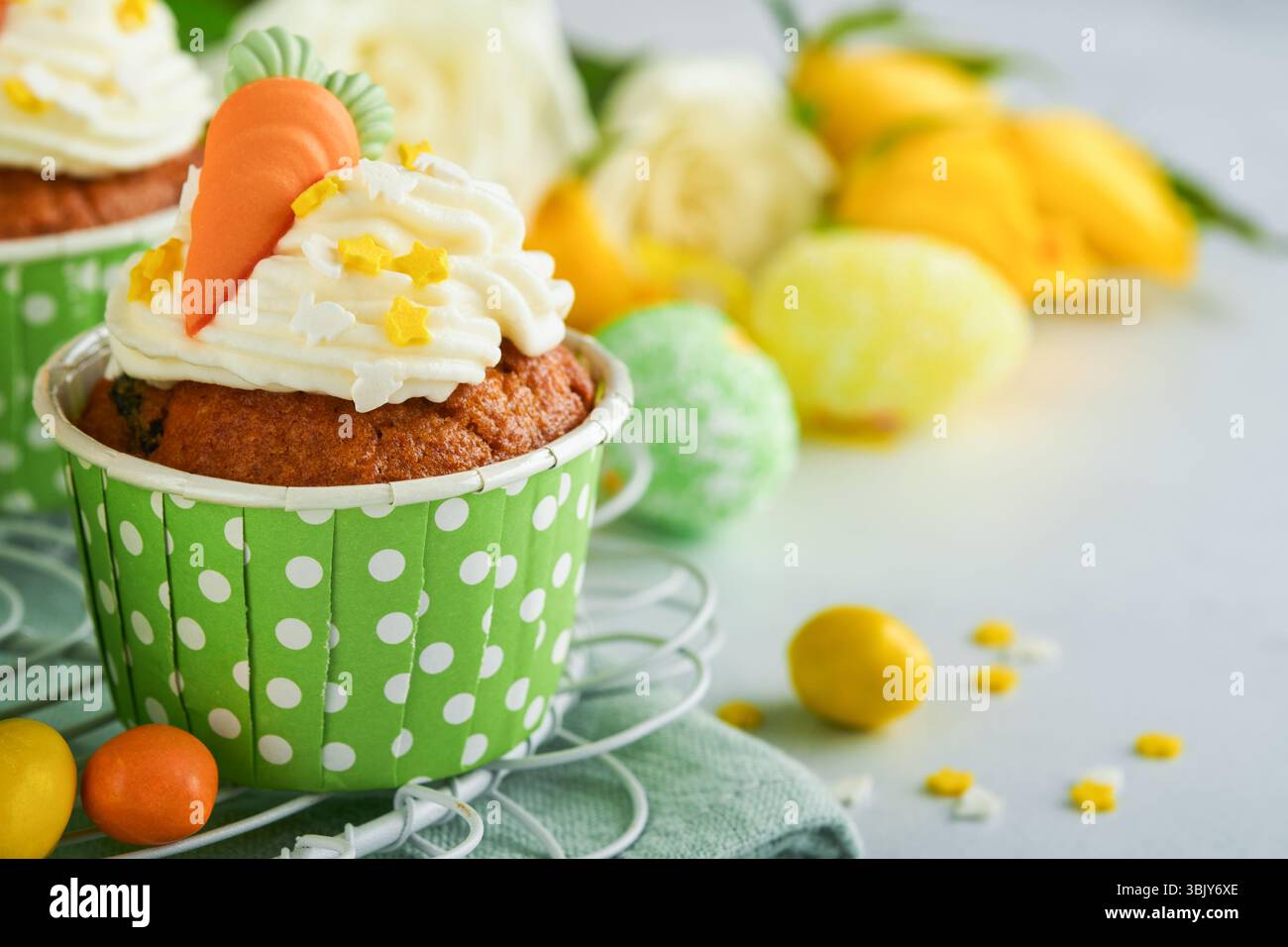 Karottenkuchen Cupcakes zu Ostern. Karotten-Cupcakes mit Frischkäse-Frosting dekoriert mit winzigen MarzipanKarotten auf weißem Backgr Stockfoto
