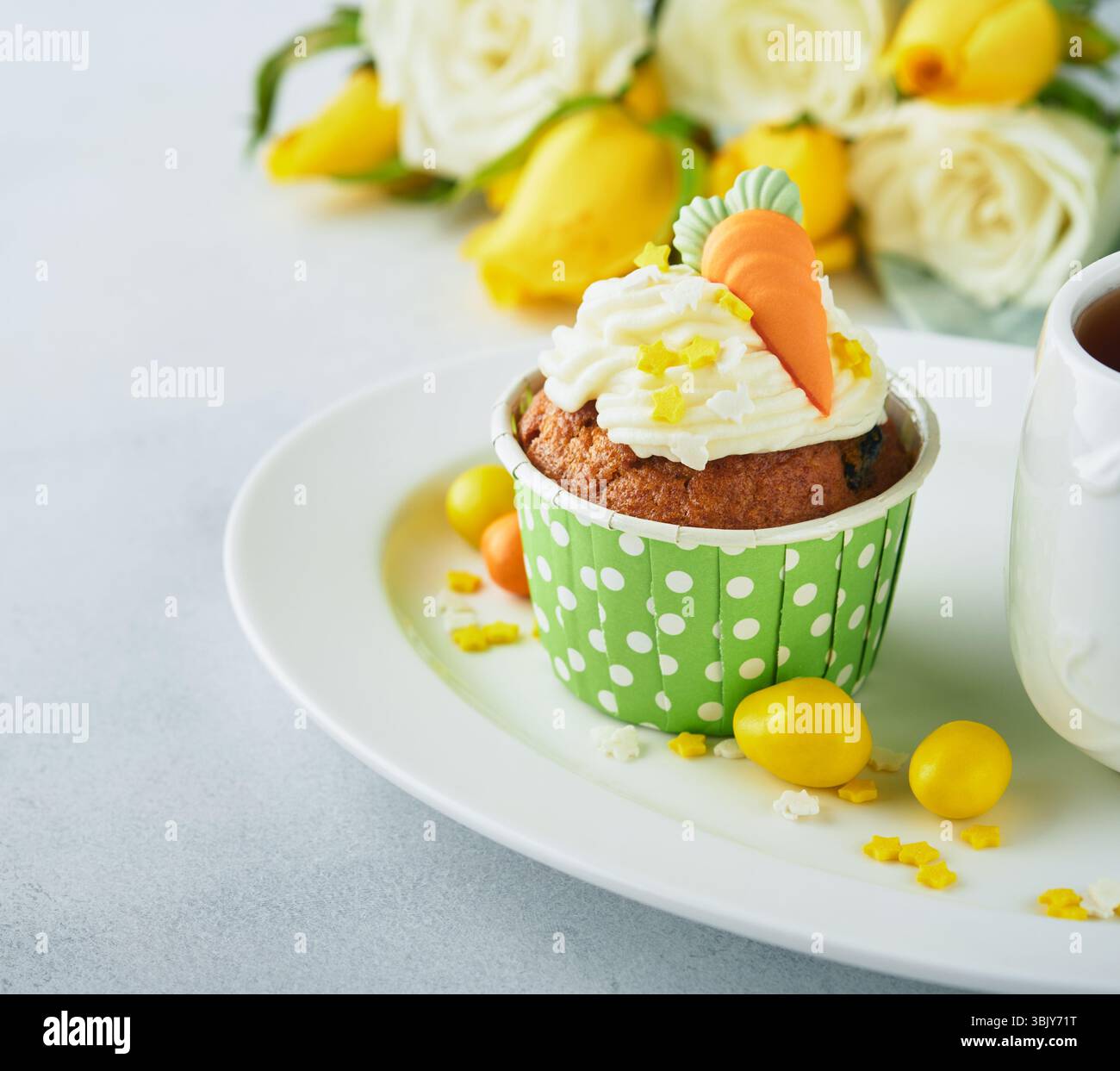 Karottenkuchen Cupcakes zu Ostern. Karotten-Cupcakes mit Frischkäse-Frosting dekoriert mit winzigen MarzipanKarotten auf weißem Backgr Stockfoto