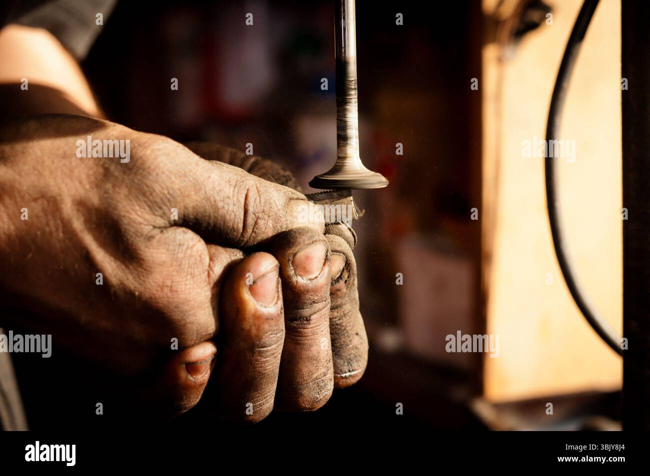 Die Hände des Arbeiters, der die metallische Oberfläche polierend Stockfoto