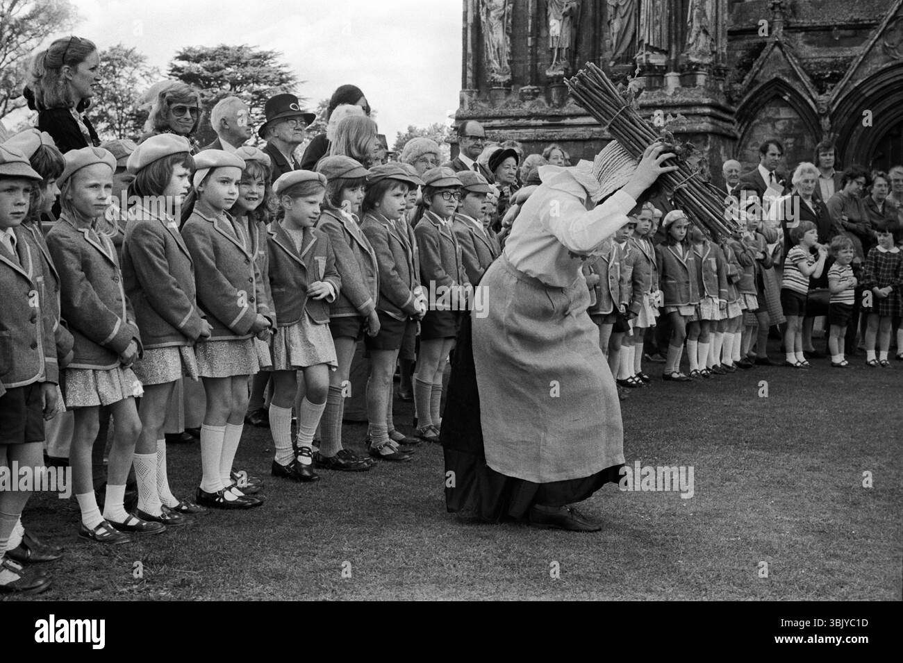 Grovely Forest Rights. Frauen aus Wishford Magna tanzen jährlich am 29. Mai vor der Kathedrale von Salisbury mit „Nitches“, Bündeln getrockneten Holzes auf ihren Köpfen. Eine Feier des Rechts, Holz aus dem Grovely Forest in Great Wishford zu sammeln. Lokale Schulkinder wurden dazu gebracht, ihre lokale Geschichte zu lernen und zu verstehen. Salisbury Wiltshire England 1974 Großbritannien 1970er Jahre HOMER SYKES Stockfoto