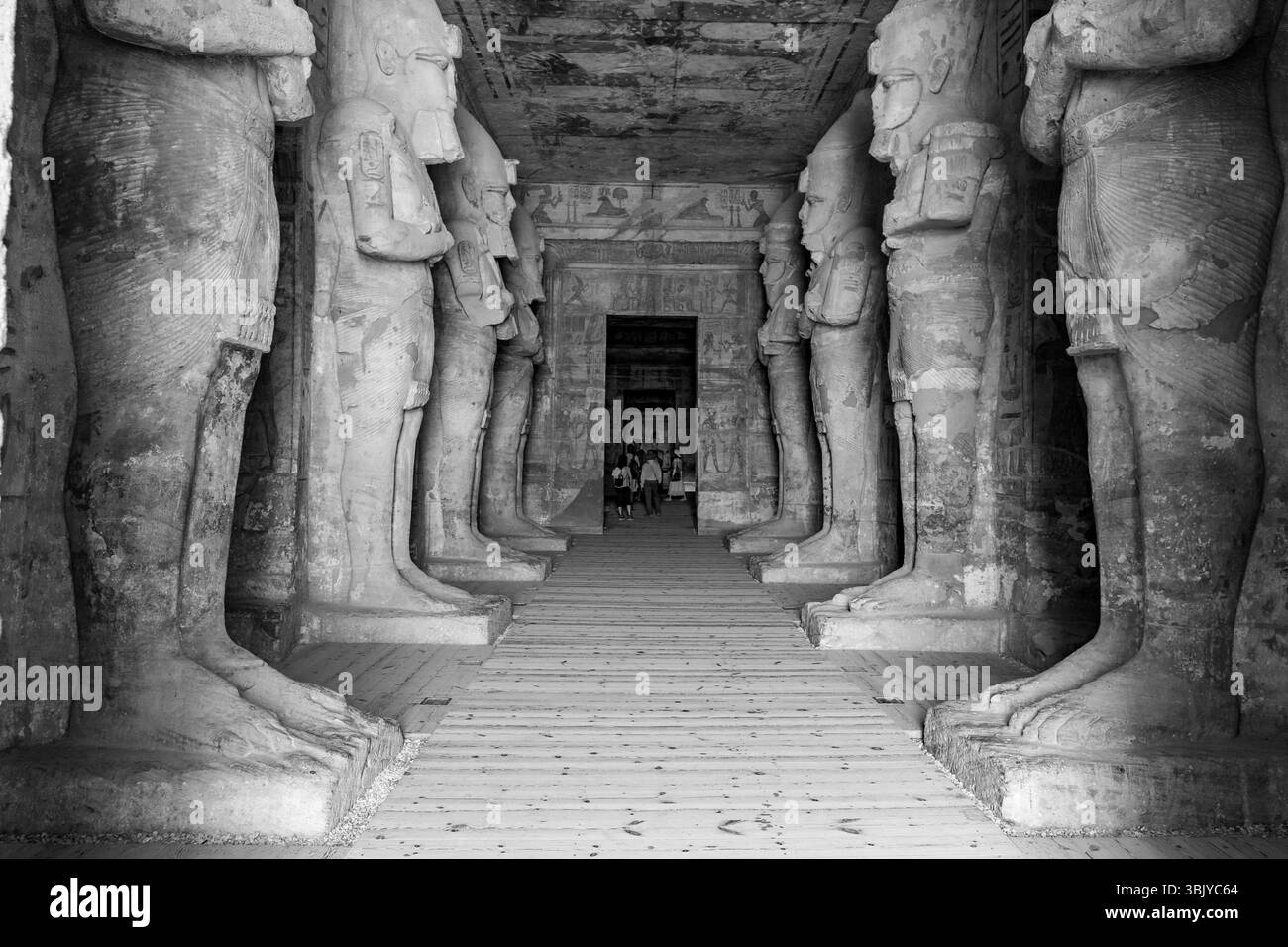Touristen spazieren durch die Halle der Statuen von Ramses II. Am Großen Tempel von Abu Simbel in Ägypten. Stockfoto