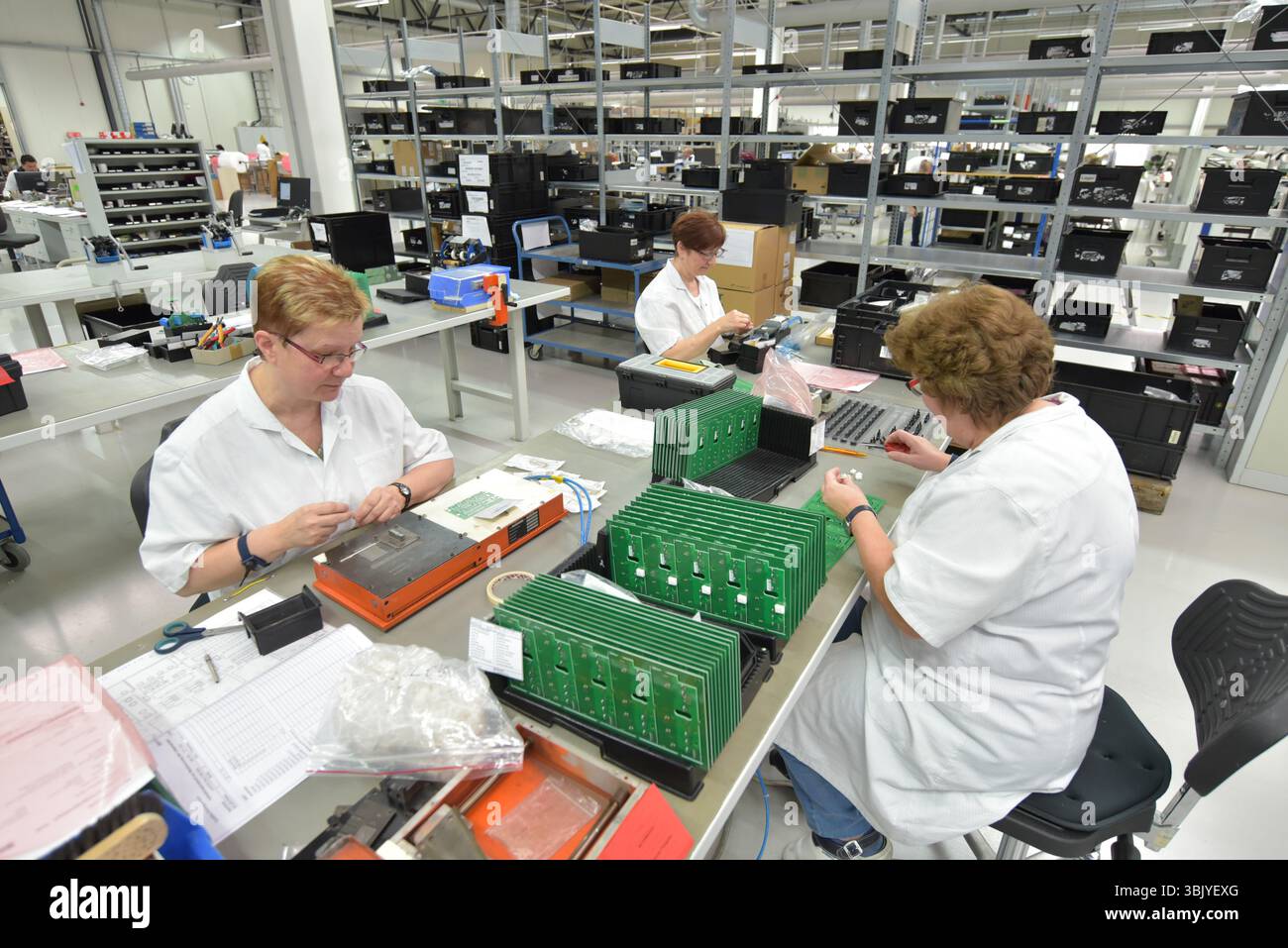 Frauen bei der Herstellung von Mikroelektronik in einer modernen Industriefabrik Stockfoto