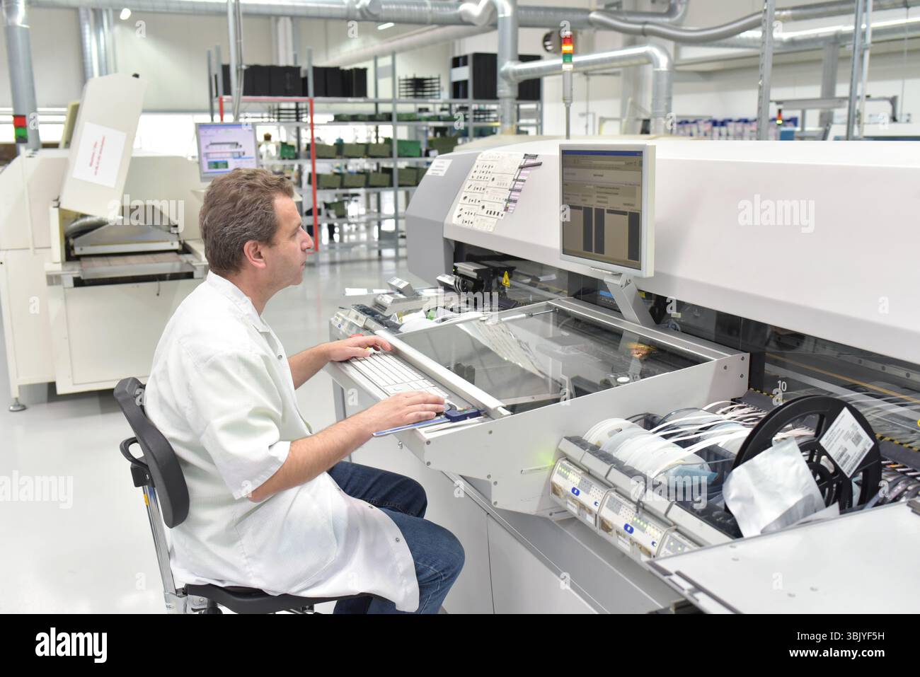 Engineering in der Mikroelektronik: Arbeiter in der Produktion und Montage von elektronischen High-Tech-Komponenten in ein modernes Werk Stockfoto