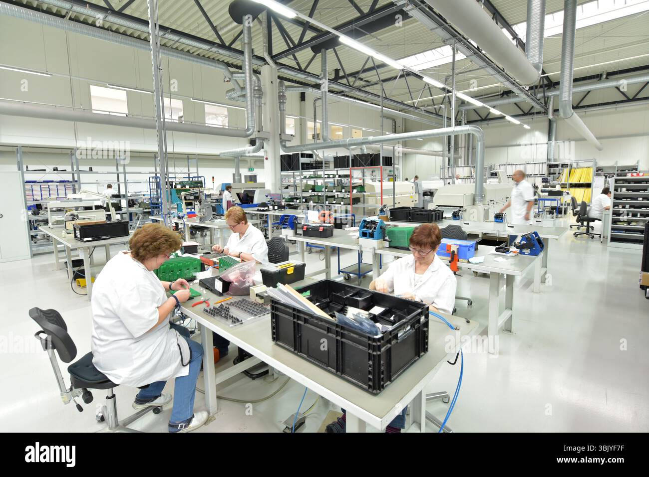 Frauen bei der Herstellung von Mikroelektronik in einer modernen Industriefabrik Stockfoto