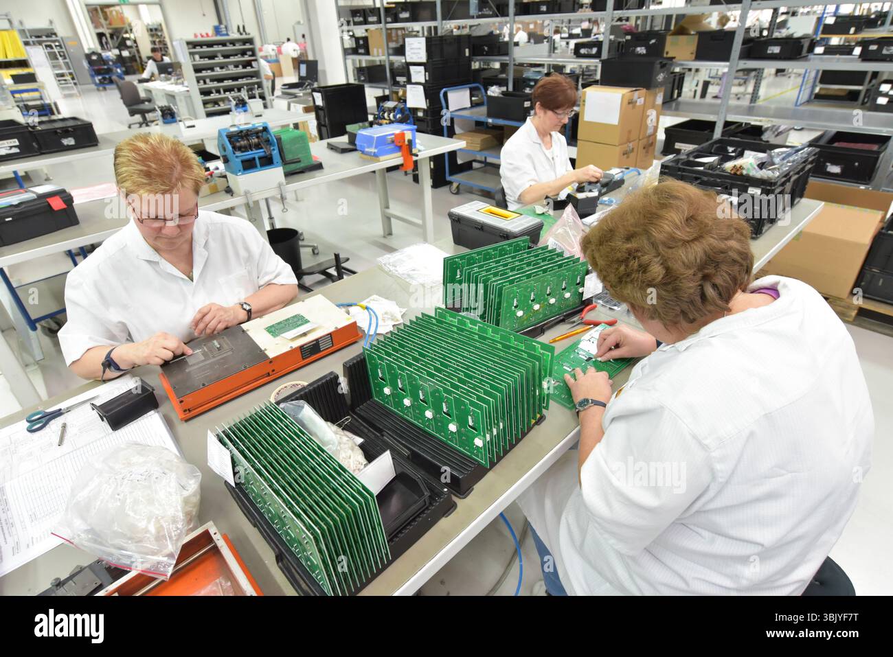 Frauen bei der Herstellung von Mikroelektronik in einer modernen Industriefabrik Stockfoto