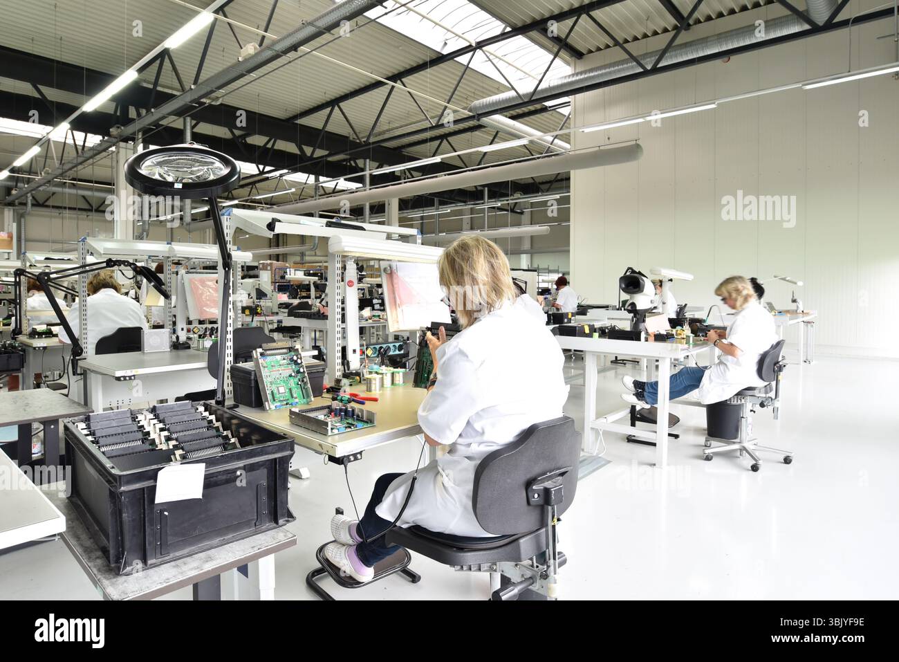 Frauen bei der Herstellung von Mikroelektronik in einer modernen Industriefabrik Stockfoto