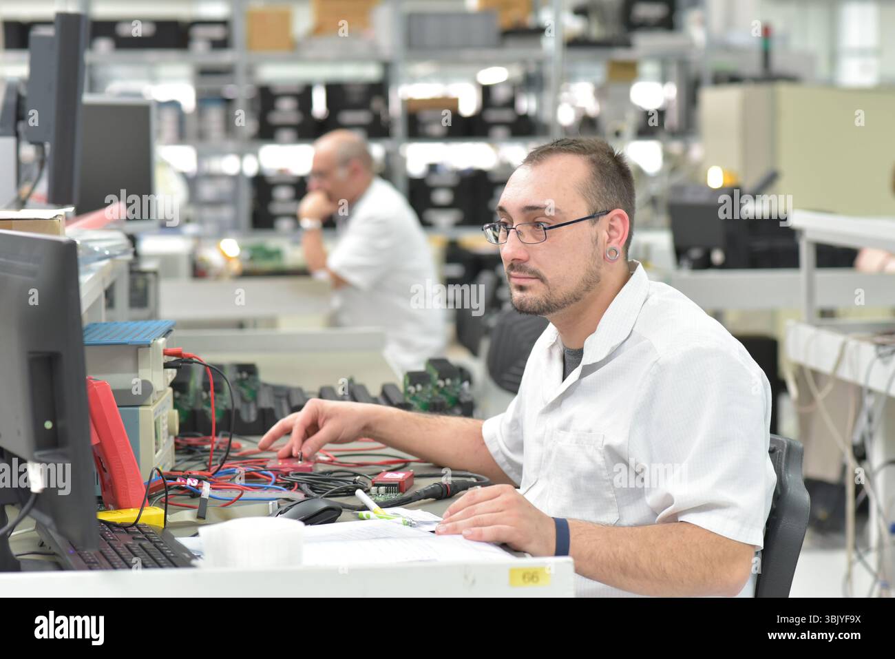 Engineering in der Mikroelektronik: Arbeiter in der Produktion und Montage von elektronischen High-Tech-Komponenten in ein modernes Werk Stockfoto