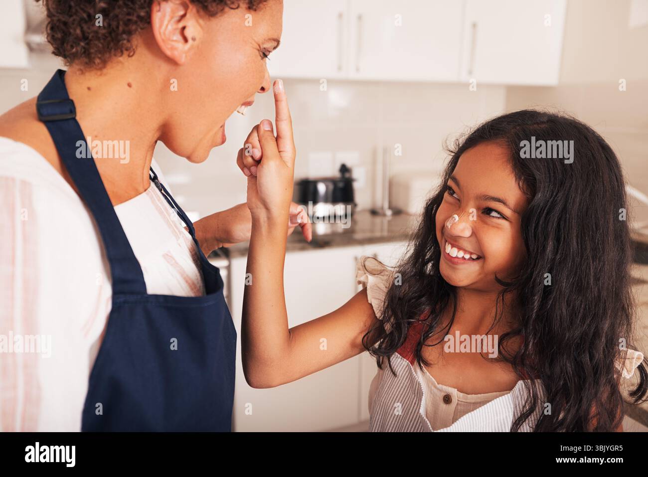 Enkeltochter und Großmutter haben Spaß zusammen in der Küche, während sie Cupcakes backen Stockfoto