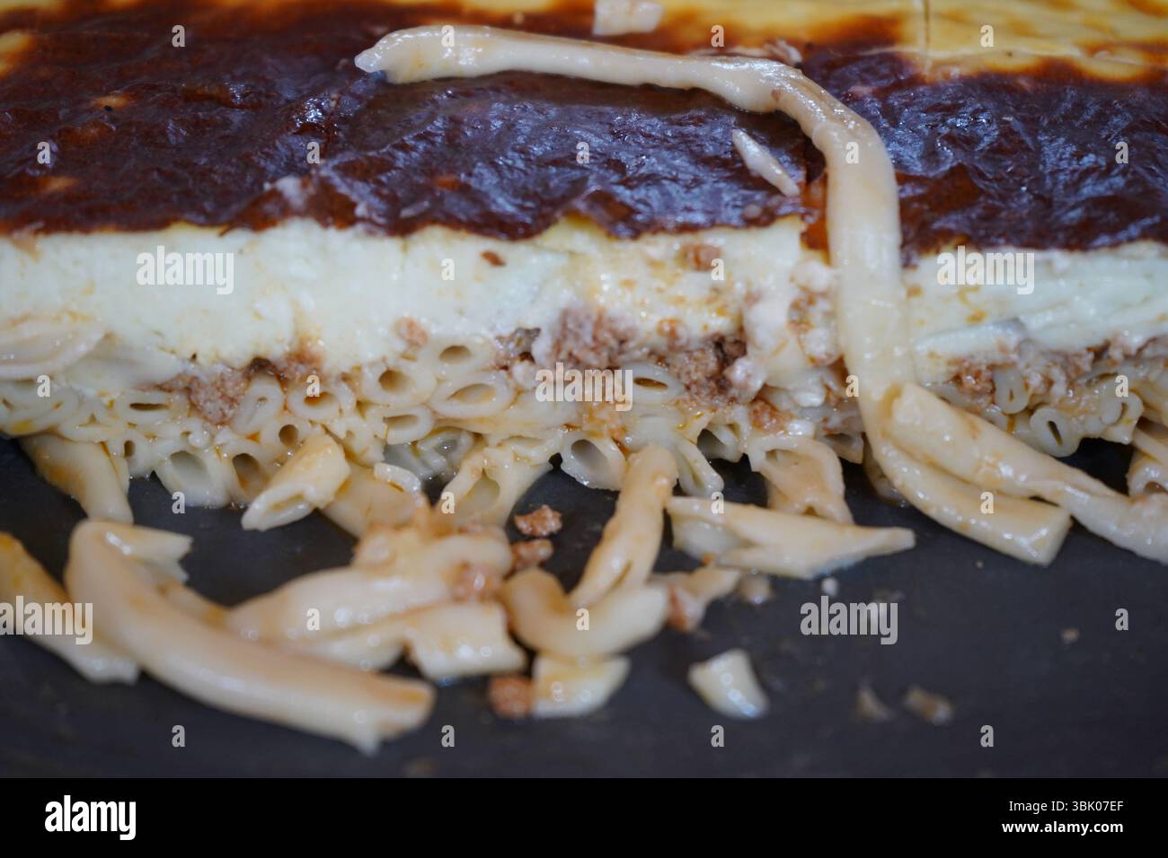 Pastitsio, traditionelle kretische Küche und Lieblingsgericht für Kinder. Ein mehrschichtiges Gericht mit Nudelröhrchen an der Basis, gekrönt mit einer gemahlenen Fleischmischung Stockfoto