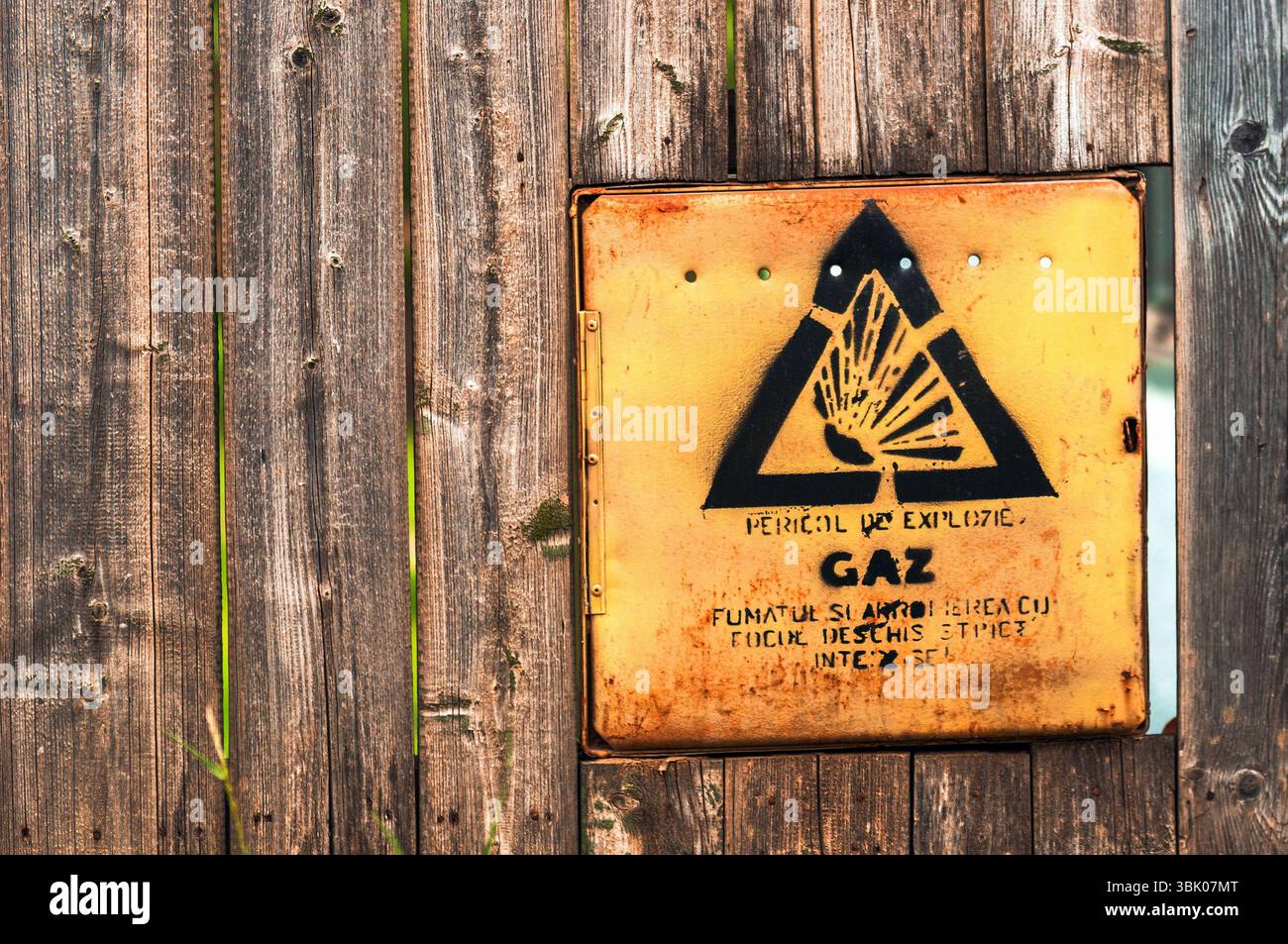 Gelbes Gefahrenschild auf dem Nahaufnahme-Foto des Holzzauns Stockfoto