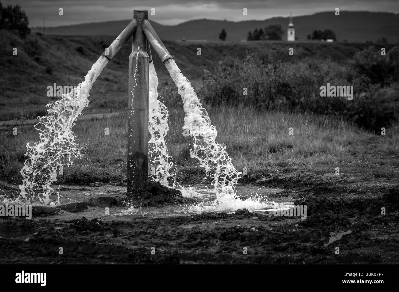 Wasser fließt aus dem Wasserhahn im Freien und wird verschwendet Stockfoto