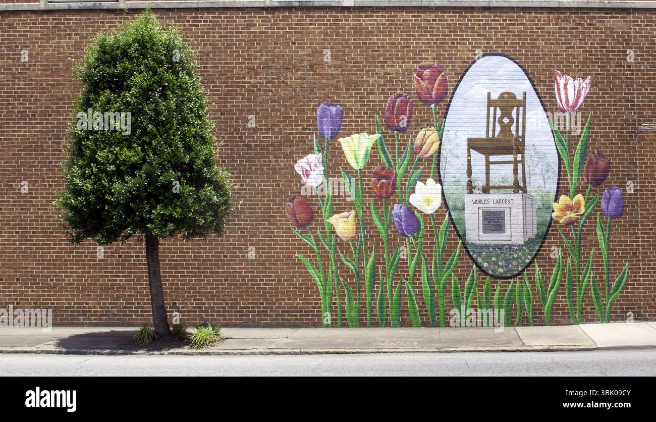 Das lebendige Wandbild eines riesigen Stuhls ziert ein Gebäude in High Point, North Carolina, und feiert das Möbelerbe der Stadt. Stockfoto