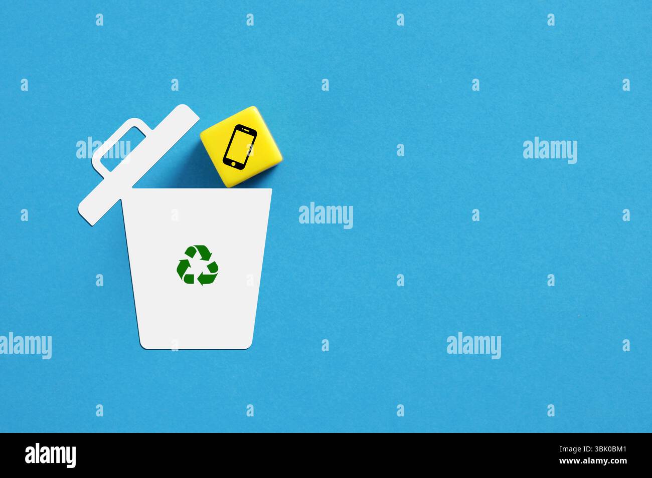 Konzeptbild für das Recycling eines elektronischen Geräts mit einem Smartphone-Symbol, das in einen Papierkorb fällt Stockfoto