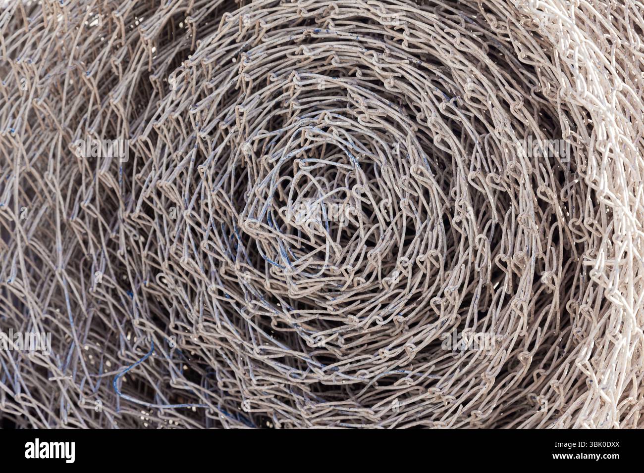 Stahlgeflecht, zu einer Rolle verdreht, Nahaufnahme. Stockfoto