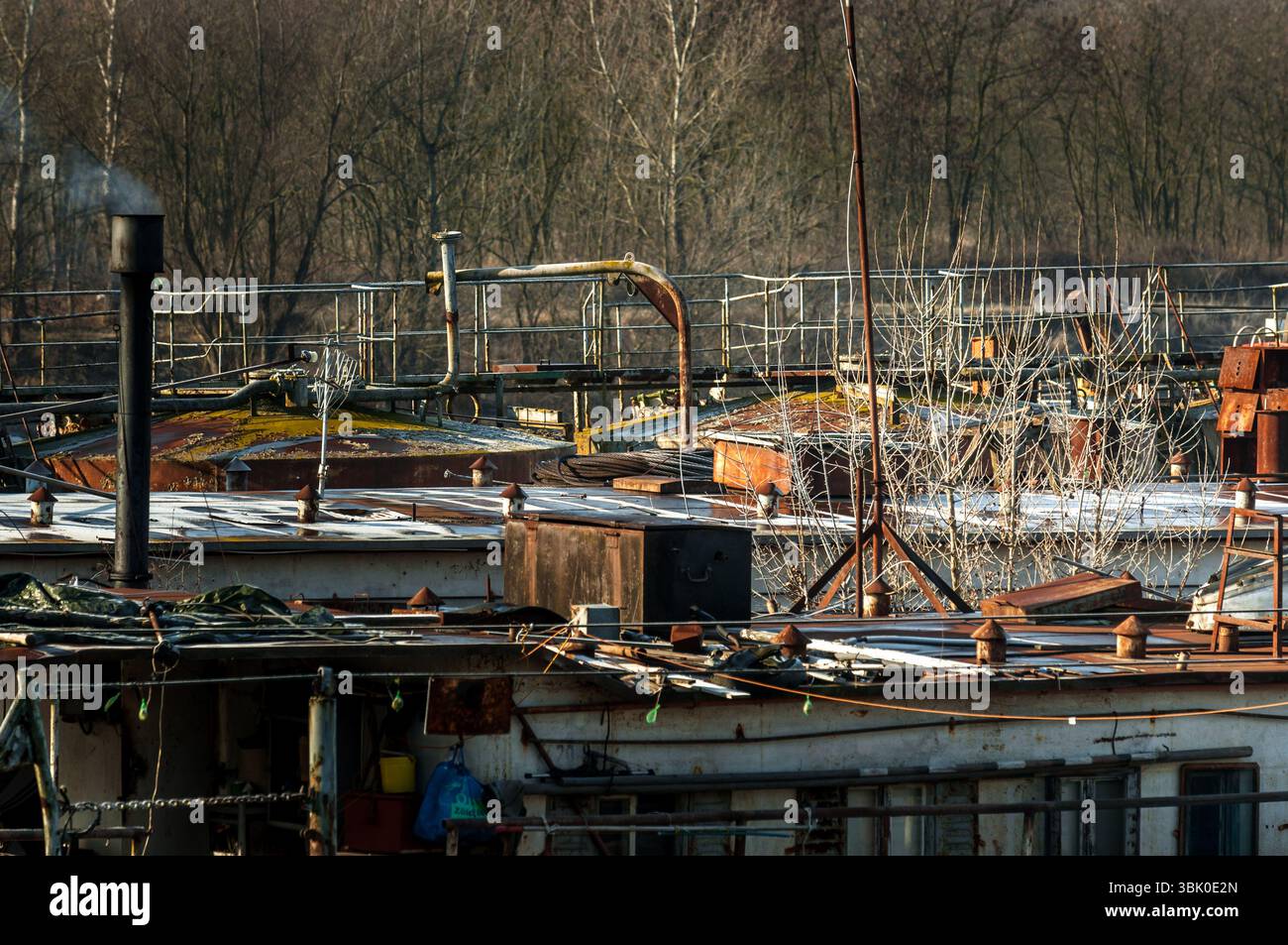 Teil einer Industrieanlage am Ufer eines Flusses im Winter Stockfoto