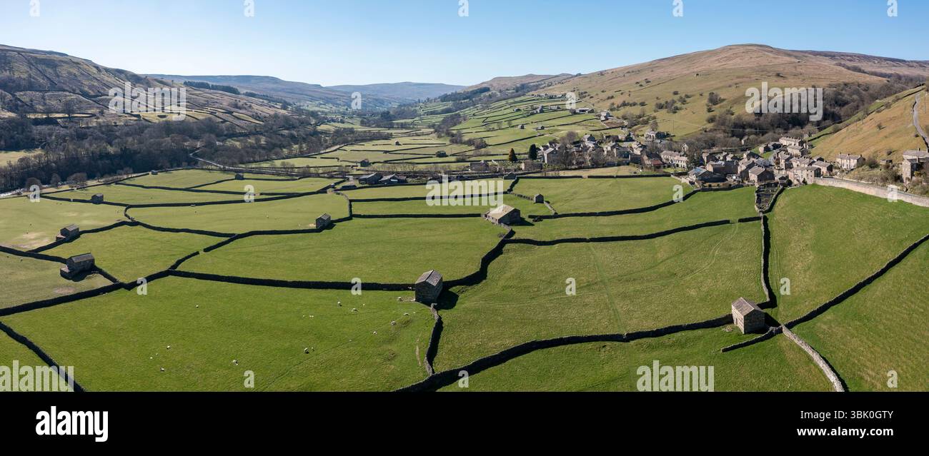 Erhöhter Panoramablick auf Patchwork-Felder und traditionelle Steinscheunen im Gunnerside Village in swaledale im Norden von yorkshire england Stockfoto