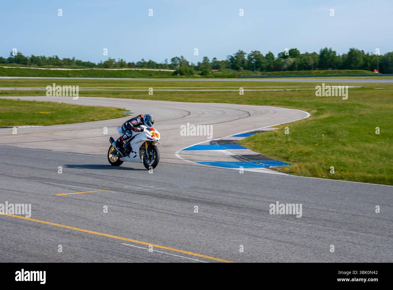 Motorradfahrer auf einer professionellen Rennstrecke in eine Kurve Stockfoto