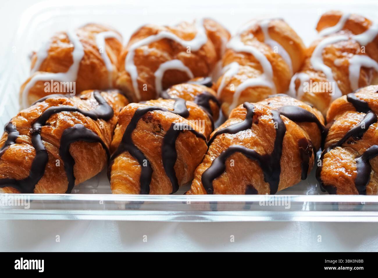 Frisch zubereitete Mini-Croissants aus weißer und schwarzer Schokolade auf einem Tablett Stockfoto