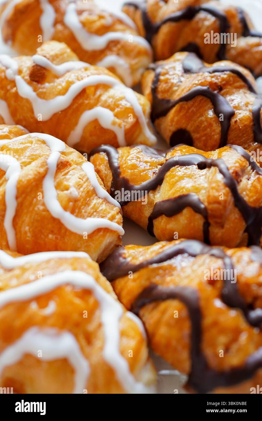 Frisch zubereitete Mini-Croissants aus weißer und schwarzer Schokolade auf dem Frühstückstisch Stockfoto
