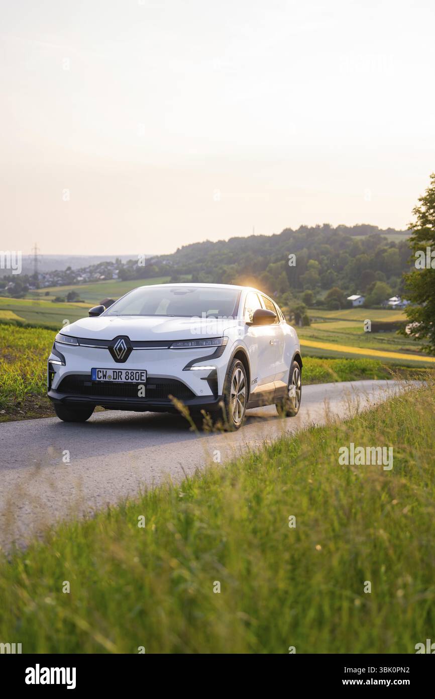 Weißes Auto fährt auf einer Landstraße in der Abendsonne, Renault Megane, Deer E-Carsharing, Elektroauto, Gechingen, Deutschland, Europa Stockfoto