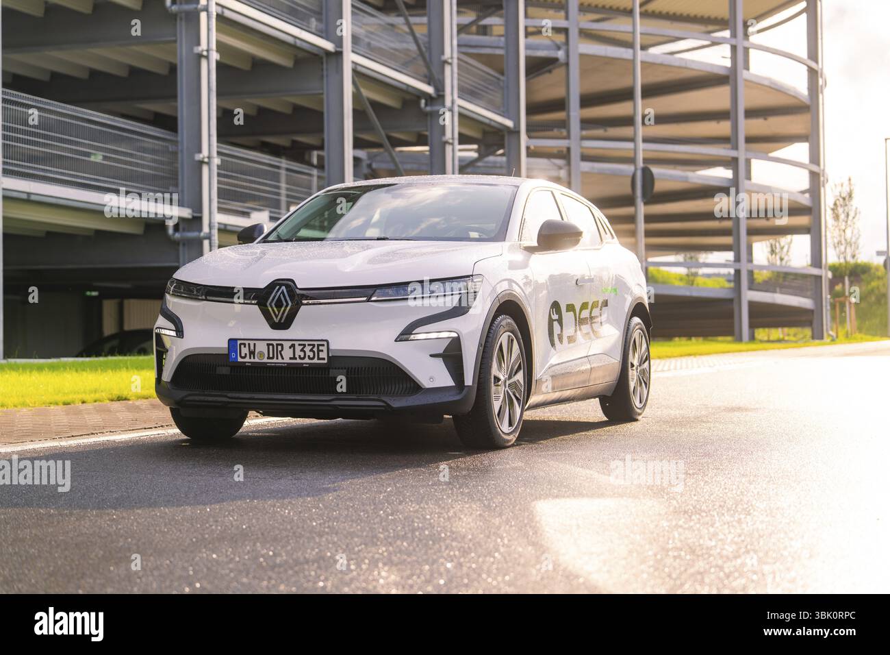Weißer Renault Wagen, der auf einer Straße vor einem Parkplatz im Sonnenlicht steht, Renault Megane, Deer E Carsharing, Elektroauto, Calw, Schwarzwald, Ge Stockfoto