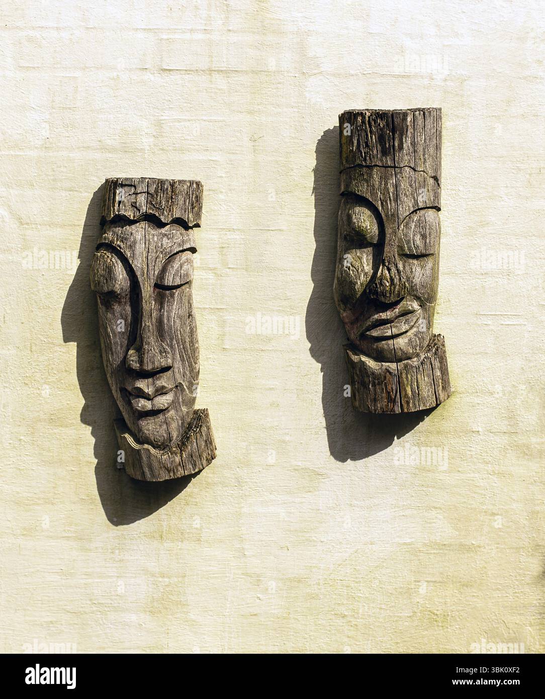 Alte afrikanische Holzmasken über einer weißen Wand Stockfoto