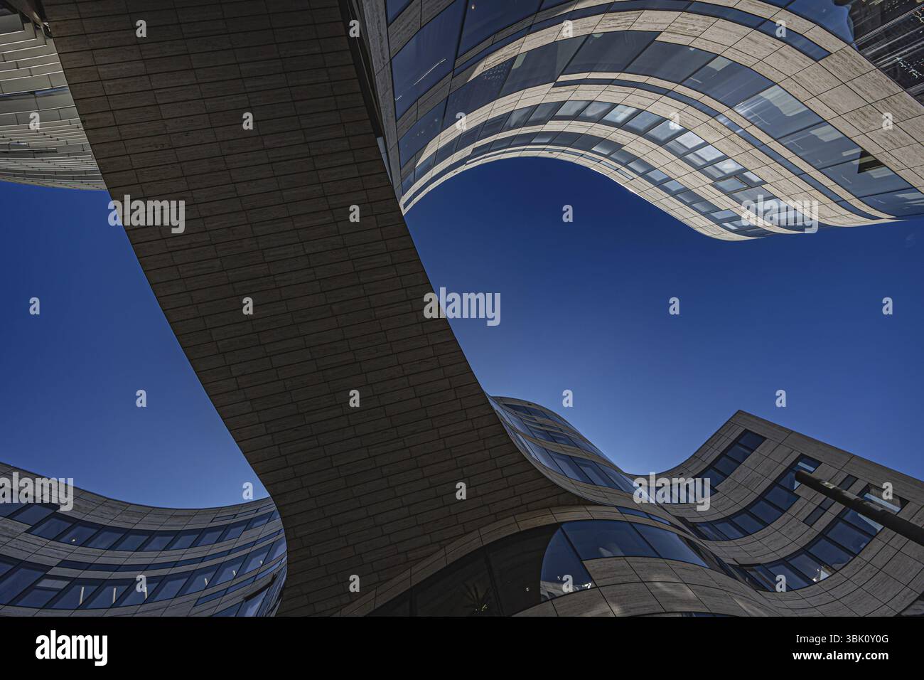 Blick nach oben zu modernen, geschwungenen Fassaden unter blauem Himmel, Koe Bogen, Düsseldorf, Nordrhein-Westfalen, Deutschland, Europa Stockfoto