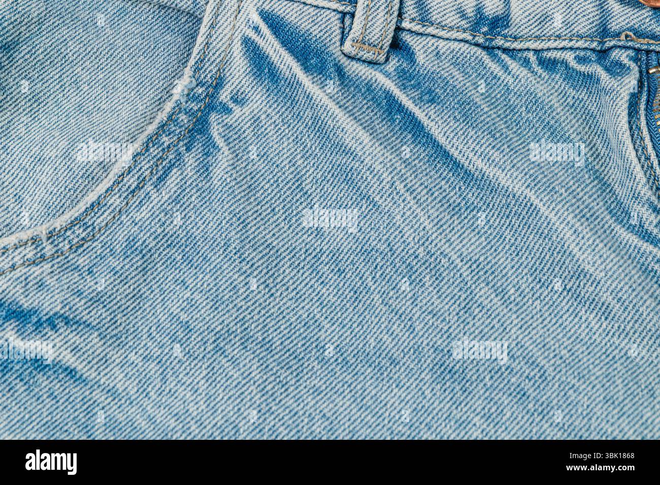 Hellblaues Denim-Material mit weicher Textur und klassischem Design, perfekt für legere Kleidung und stylische Outfits zu jeder Jahreszeit. Stockfoto
