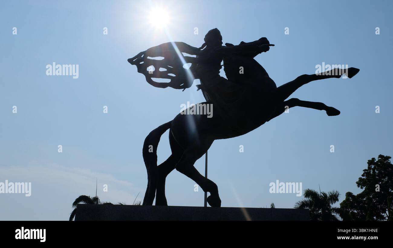 Eine auffällige Silhouette der Prinz Diponegoro Statue am Monumen Nasional (Nationaldenkmal) in Jakarta, Indonesien, vor einem hellen Himmel Stockfoto