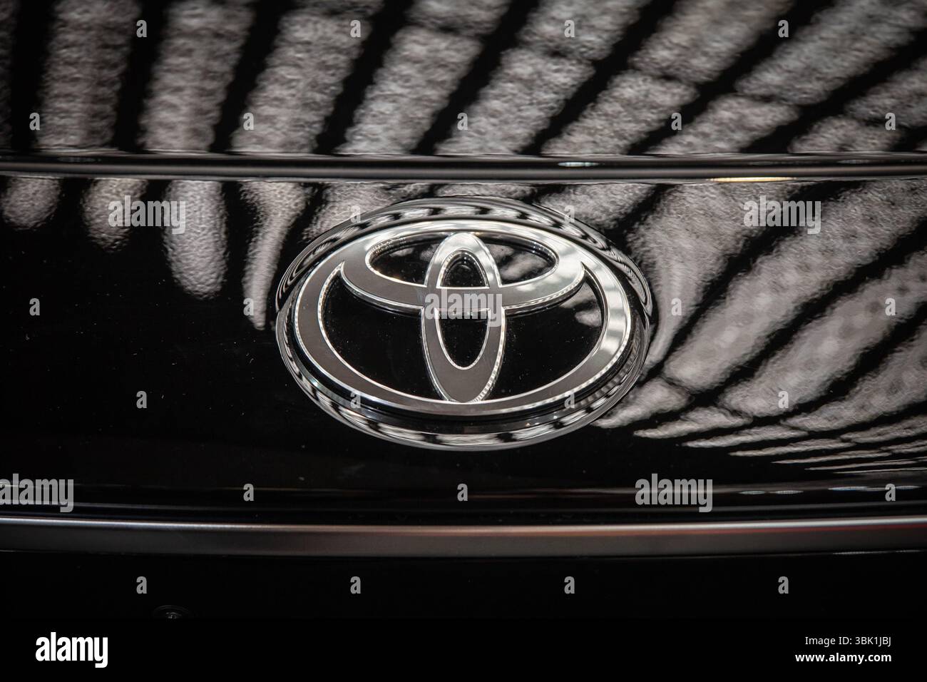 BELGRAD, SERBIEN - 22. MÄRZ 2025: Verchromtes Toyota-Emblem auf der tiefschwarzen Front eines Autos in Belgrad, Serbien. Toyota ist ein japanischer Automobilhersteller Stockfoto