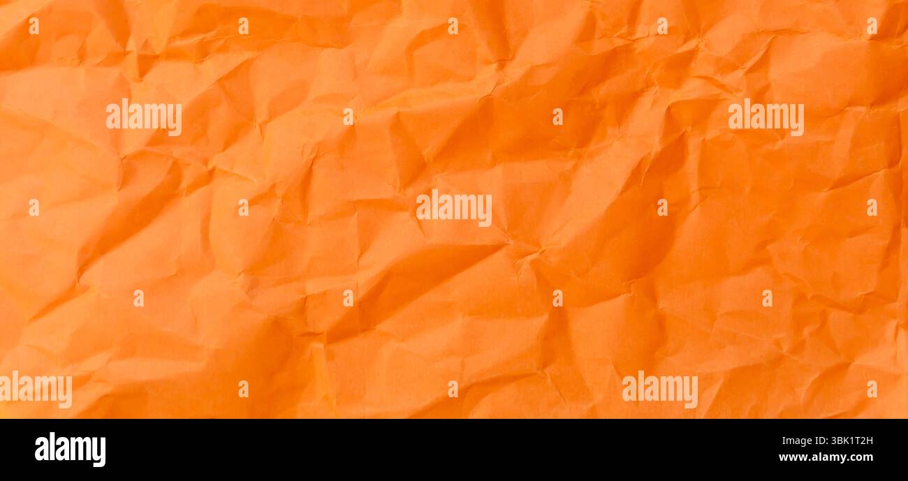 Die Ansicht von oben und der ganze Rahmen von zerknittertem oder zerknittertem orangefarbenem Papier wird als zerknitterte Papierhintergrundstruktur bei dekorativen Kunstwerken verwendet. Stockfoto