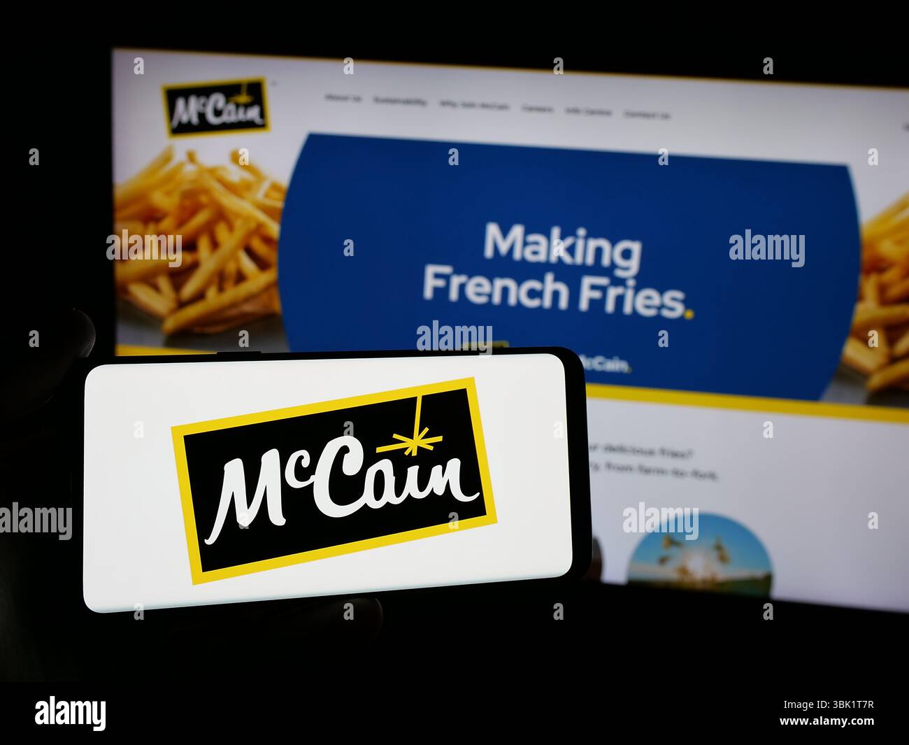 Stuttgart, Deutschland - 24.04.2025: Person, die ein Smartphone mit dem Logo des kanadischen Lebensmittelunternehmens McCain Foods Limited auf dem Bildschirm vor der Website hält. Stockfoto