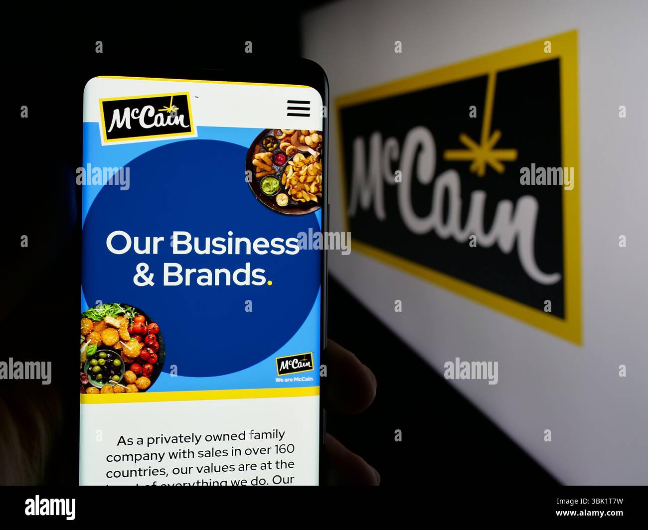 Stuttgart, Deutschland - 24.04.2025: Person, die ein Mobiltelefon hält, mit Webseite des kanadischen Lebensmittelunternehmens McCain Foods Limited auf dem Bildschirm vor dem Logo. Stockfoto