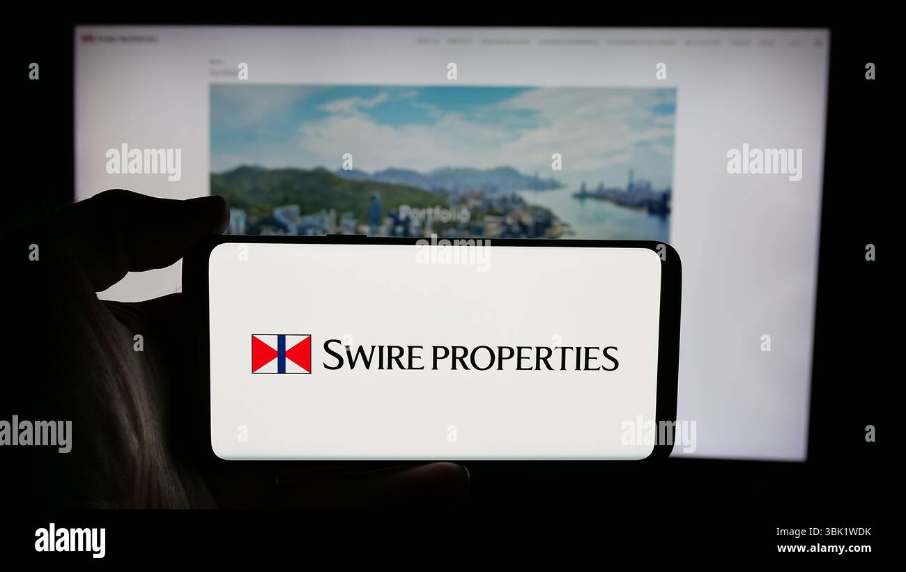 Stuttgart, Deutschland - 26.04.2025: Person, die ein Mobiltelefon mit dem Logo der Immobilienfirma Swire Properties Limited auf dem Bildschirm vor der Webseite hält. Stockfoto