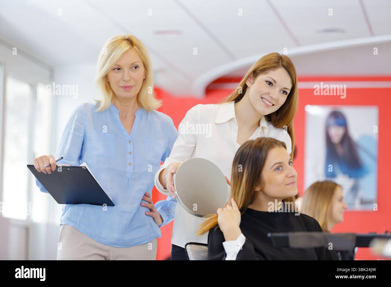 Frisör-Auszubildende, die das Ergebnis des Kunden überprüft Stockfoto